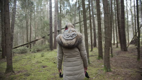 slow motion: woman starts her walk in the woods with her dog