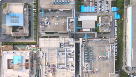 overhead shot of industrial big factory warehouse rooftop. aerial drone shot camera flying forward. factory rooftop, roof windows, ventilation shafts, flat roof of a big manufacture warehouse.