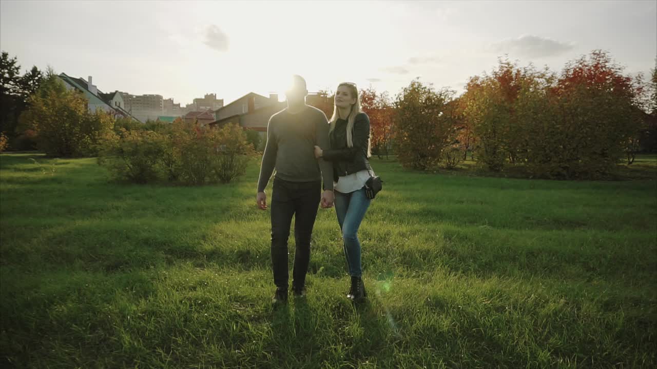 Couple Walking in a Park at Sunset