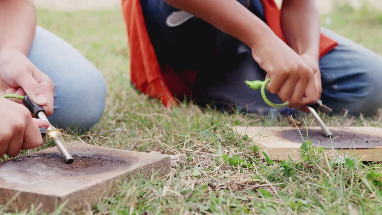 옥외 캠핑 여행 에 있는 어린이 들 의 그룹 이 불 을 피우는 법 을 배우고 있다