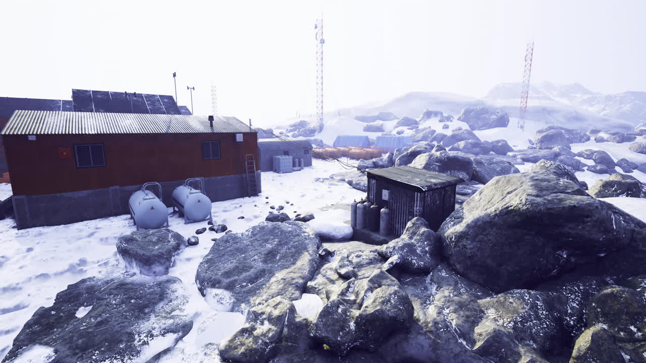 paisaje nevado con estaciones de investigación y terreno rocoso en una ubicación remota