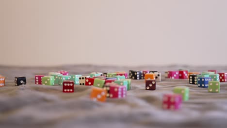 rolling brigh red glass looking dice onto a large pile of other colored dice