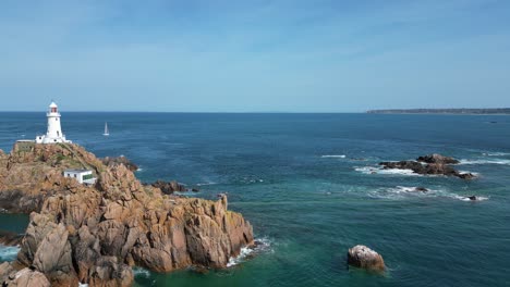 Low-panning-drone-aerial-La-Corbière,-Jersey