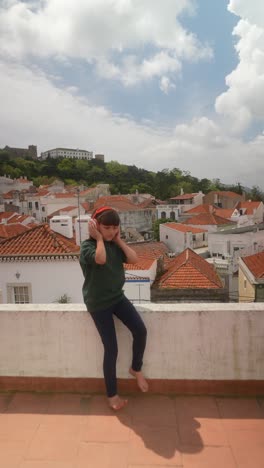 Girl with headphones on a rooftop in a European city