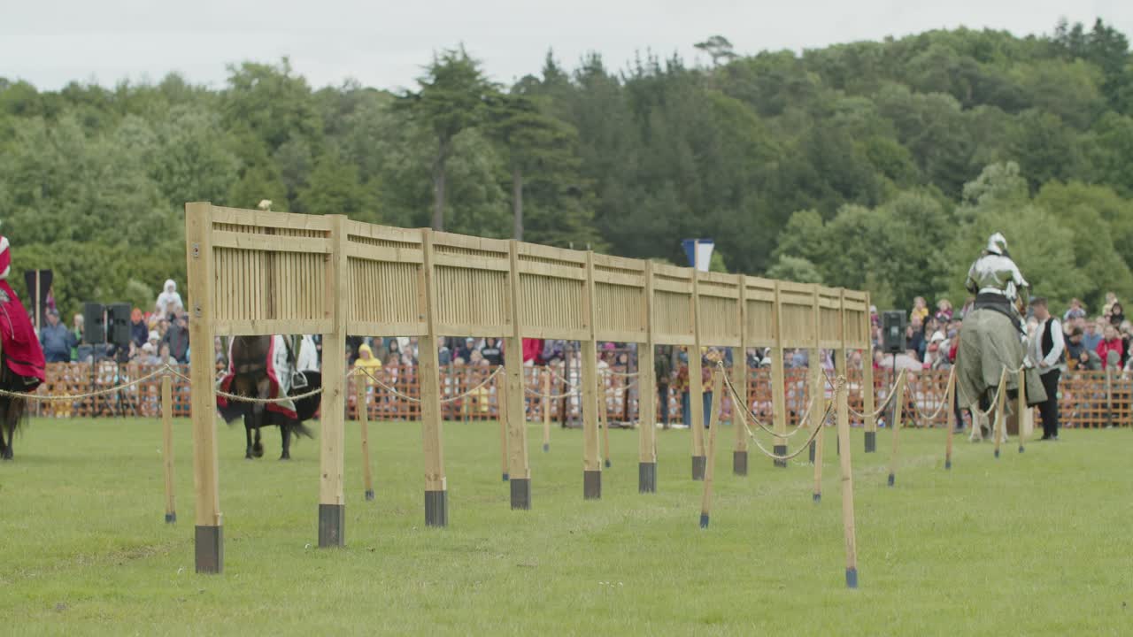 Armoured knights riding their horses to warm up as they enter the arena during a medieval tournament Joust at Leeds Castle, Kent, England