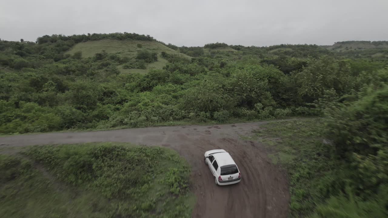 Ripresa aerea che segue un veicolo che percorre una strada sterrata nelle montagne tropicali della Colombia