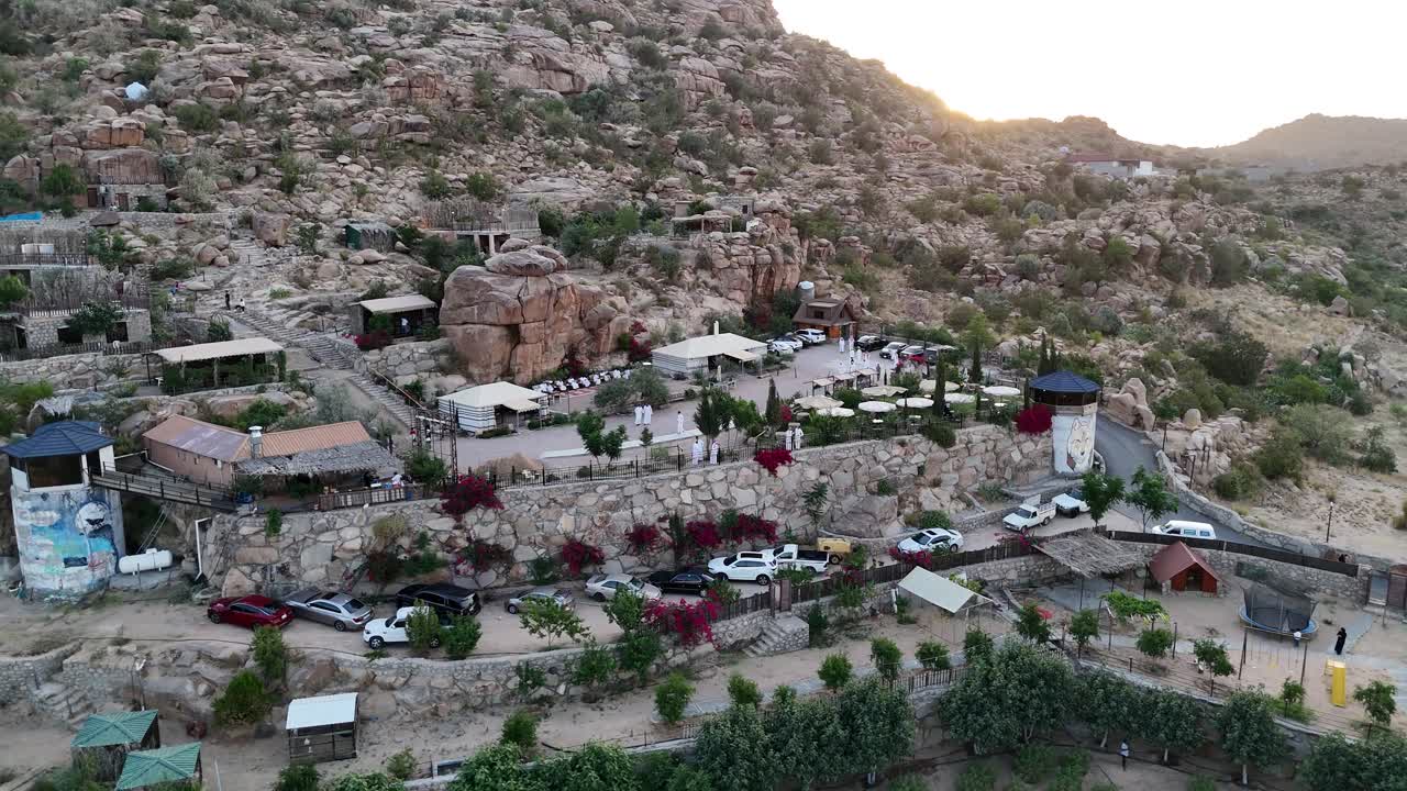 Aerial view circling a hillside town, sunny evening in Taif, Saudi Arabia