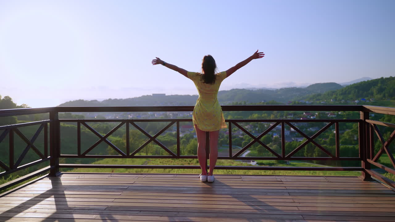 mujer disfrutando de una vista panorámica desde un balcón en la cima de una montaña