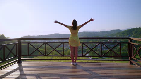 woman enjoying a scenic view from a mountaintop balcony