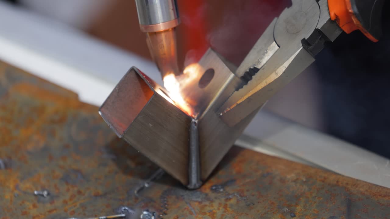 Macchina per saldatura laser con saldatore a pistola. La saldatura laser è mostrata in primo piano