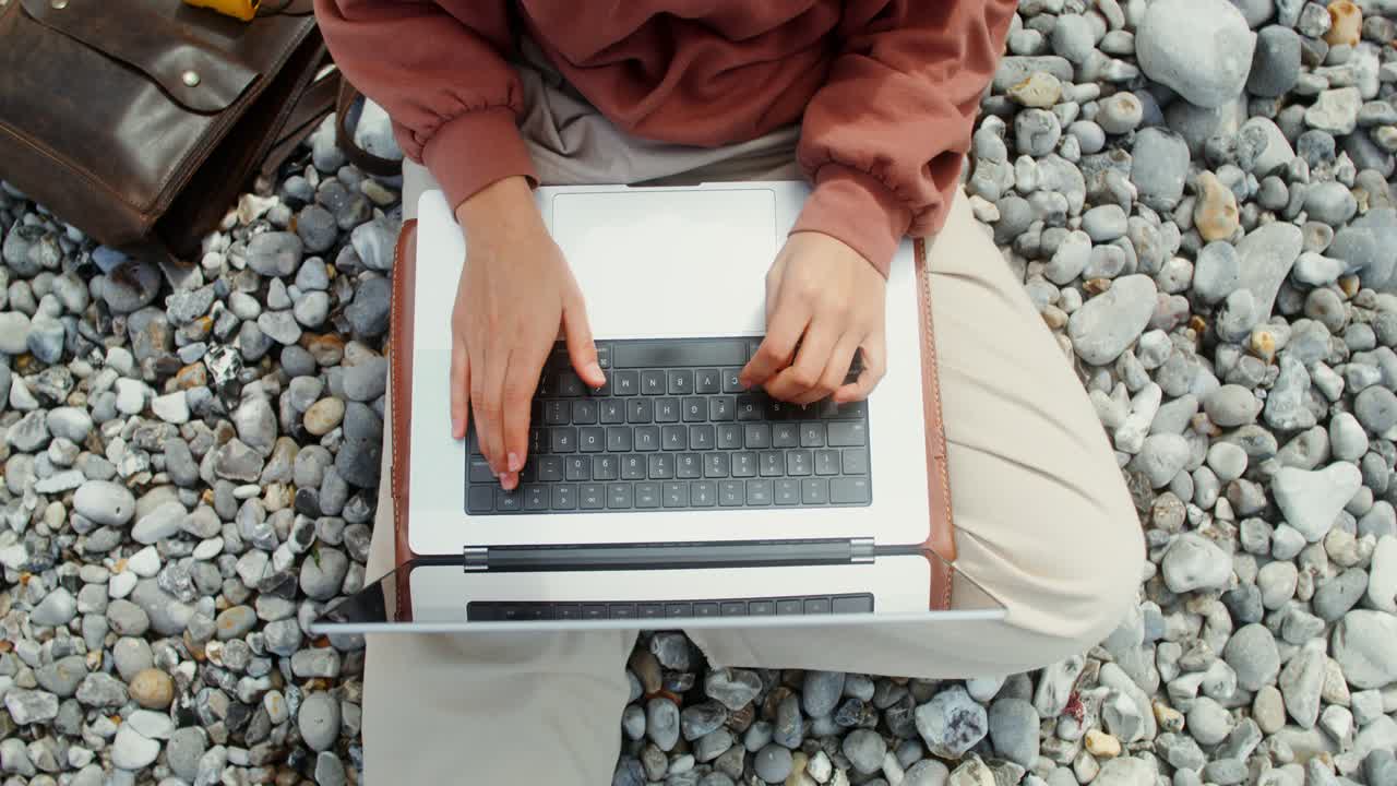 mujer trabajando en una computadora portátil en la playa