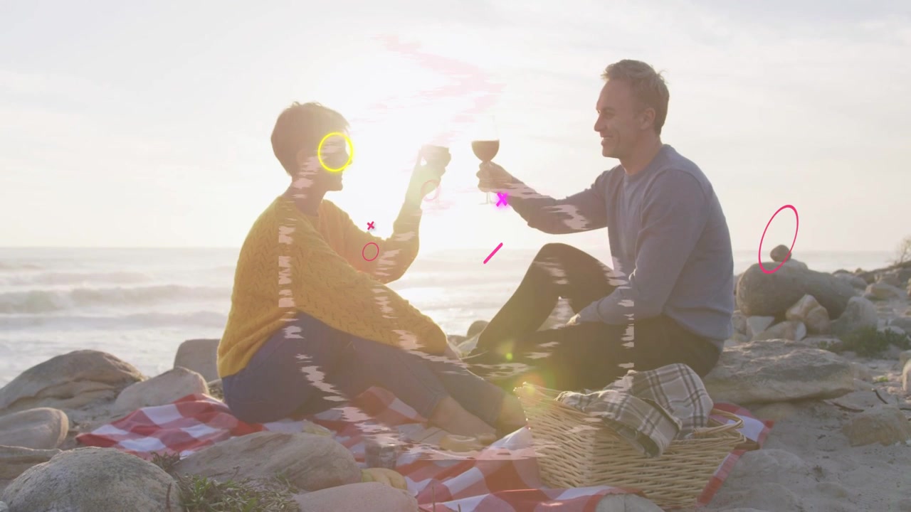 Pareja madura brindando con copas sobre una manta a cuadros al atardecer, generando efectos de glitch animados para anuncios.
