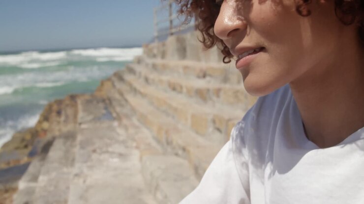 Mujer usando teléfono móvil en la playa 4k