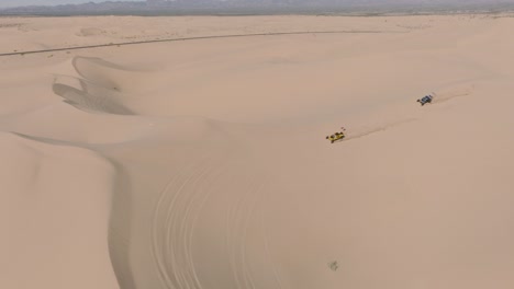 aventureros de dunas de arena, imágenes aéreas de drones de vehículos todoterreno conduciendo sobre arena en glamis california