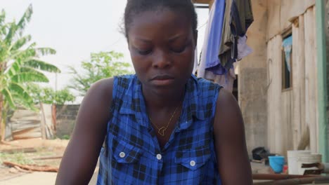 close up of black african woman cooking food chopping vegetable for traditional ghana cuisine fufu preparation