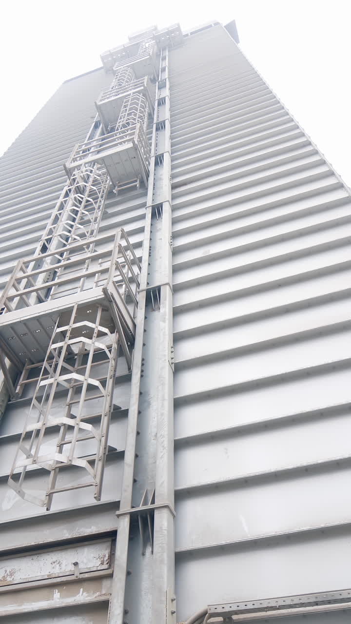 Esterno di un grande edificio industriale con scale di accesso.