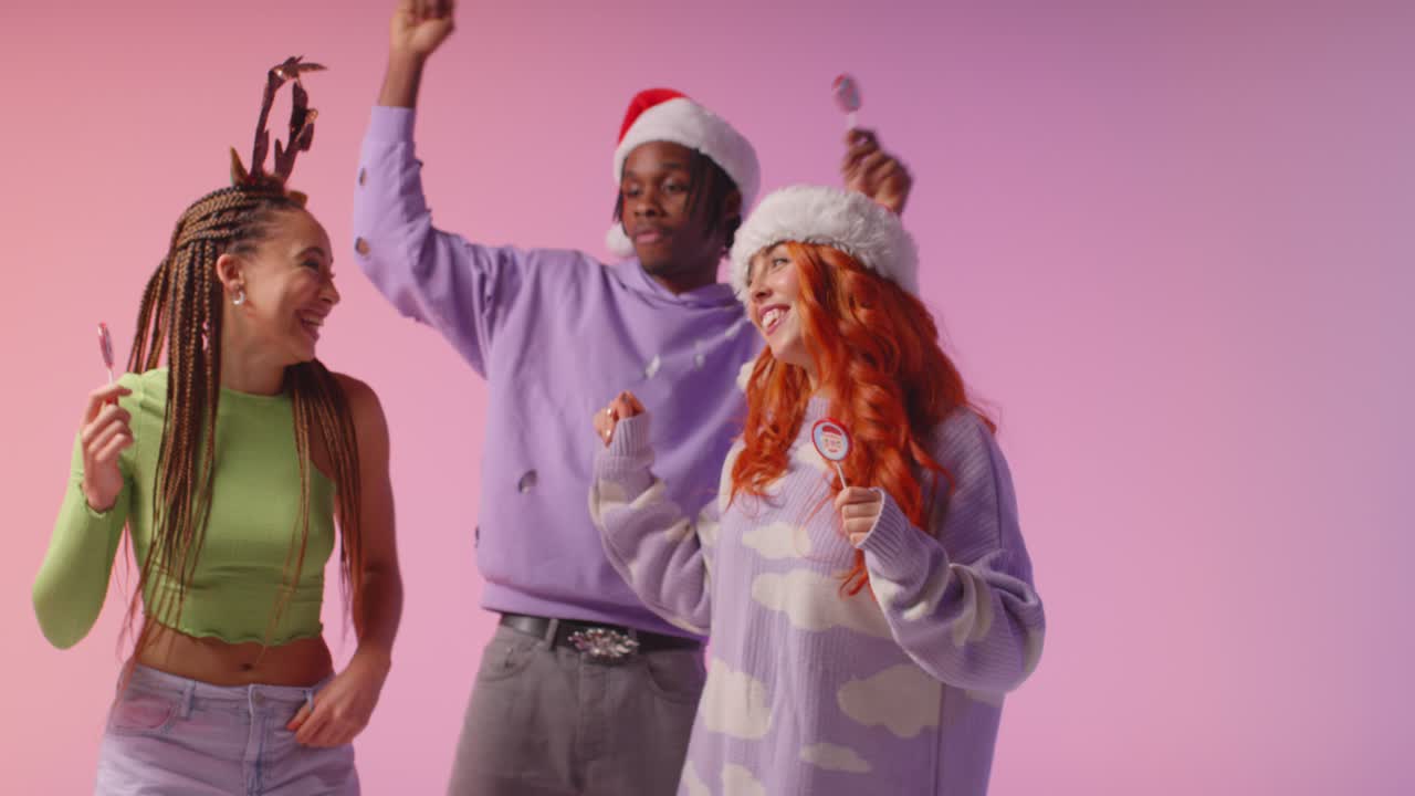 fotografía de estudio de amigos de la generación z bailando en una fiesta de navidad con sombrero de papá noel y cuernos de reno 2