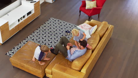 overhead shot of father playing with children in lounge