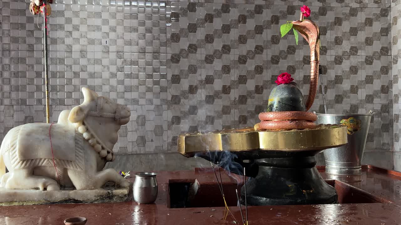 Lingam sacro di Shiva con sacre preghiere e offerte floreali all'interno del tempio.
