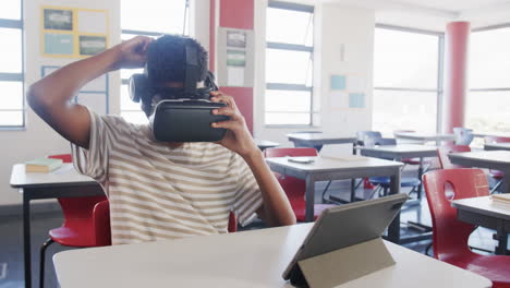 in school, boy using vr headset and tablet in classroom, exploring technology