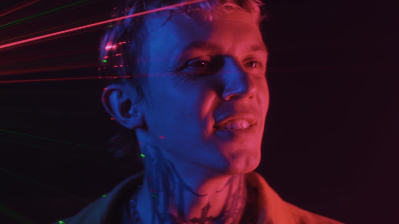 Male Nightclub Visitor Moving to Music in Neon Light