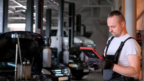 a mechanic uses a diagnostic tool in an auto repair shop