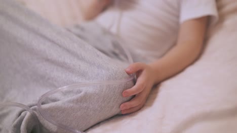 child undergoes procedure with inhaler in bed focus on hand