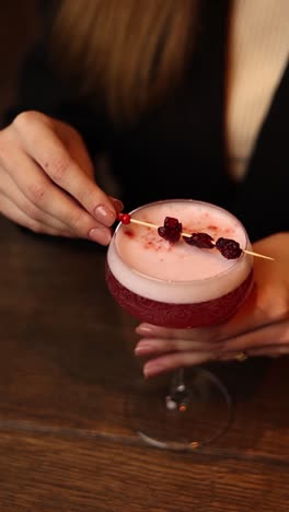 woman holding a delicious pink cocktail