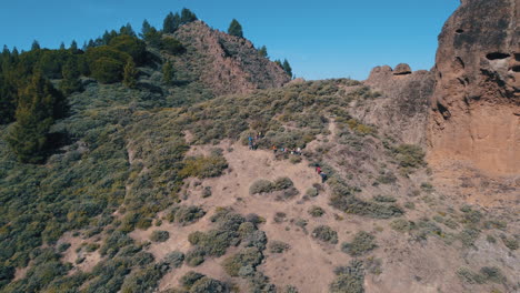 fantastic aerial shot in distance and revealing the roque saucillo and where there is a group of tourists going down the mountain