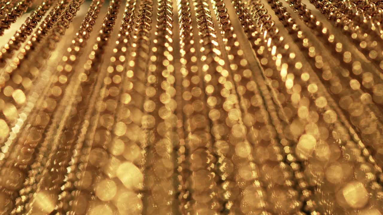 긴 금 사슬의 느리고 부드러운 움직임, 균일한 스, 휴식을 위한 금색 배경, 명상, 휴식, 진정시키기 위한 질감, 반이는 빛, 아래에서 위로 보이는 광경, 흐릿한 빛.