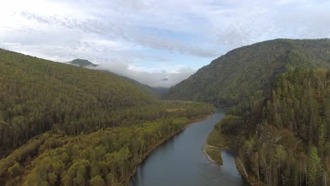 aerial view of a river winding through a forest valley