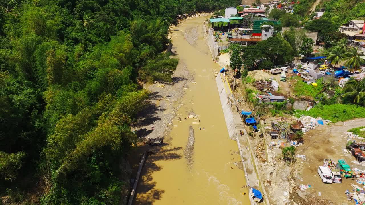 Drone flies forward above muddy Mananga River after typhoon floods in Cebu