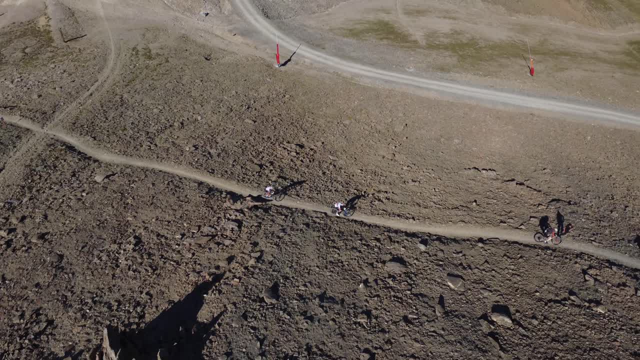 Drone footage of a solo biker standing triumphantly at the summit above Ischgl. Perfect for sports, motivation, or outdoor adventure content
