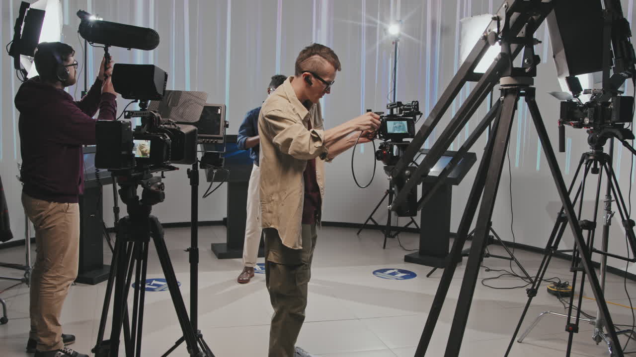 Filmmaking Crew Adjusting Shooting Equipment In Studio