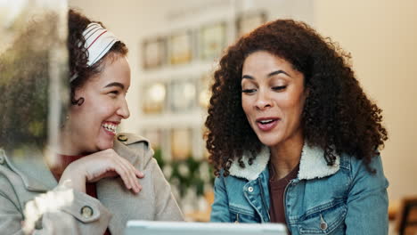 two women smiling at a laptop