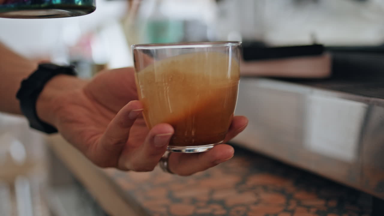 manos preparando café fresco en el restaurante de primer plano. barista desconocido vertiendo leche