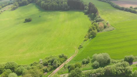 volando sobre colinas con campos en un campo rural