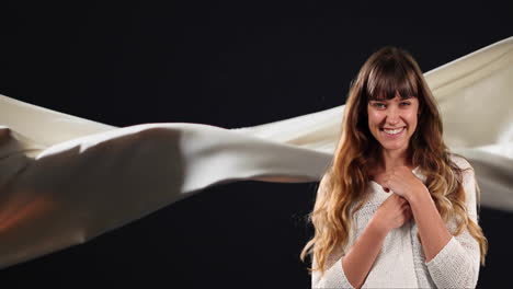 animation of happy caucasian woman over floating cloth on black background