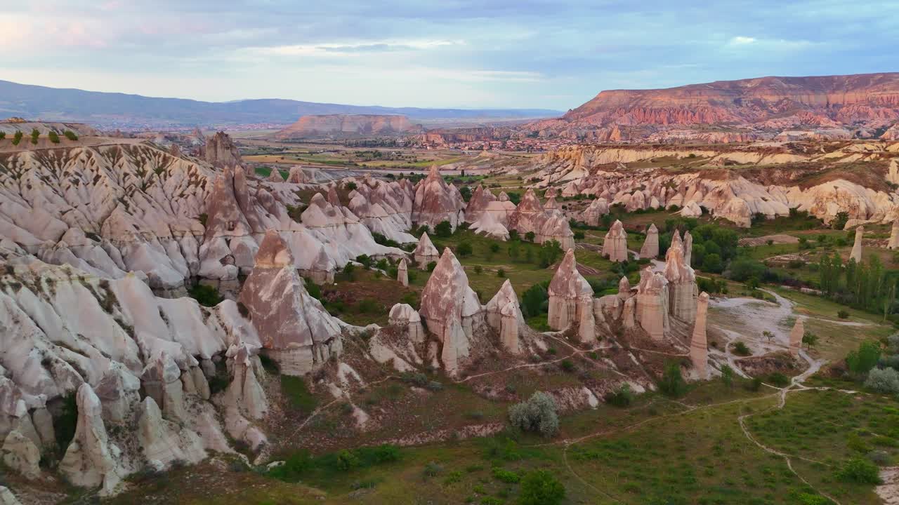 Aerial view of Cappadocia's unique rock formations at sunset, serene landscape