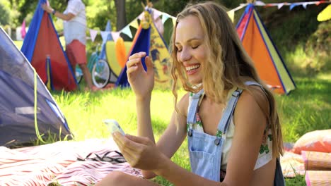 una mujer hipster mirando su teléfono móvil.