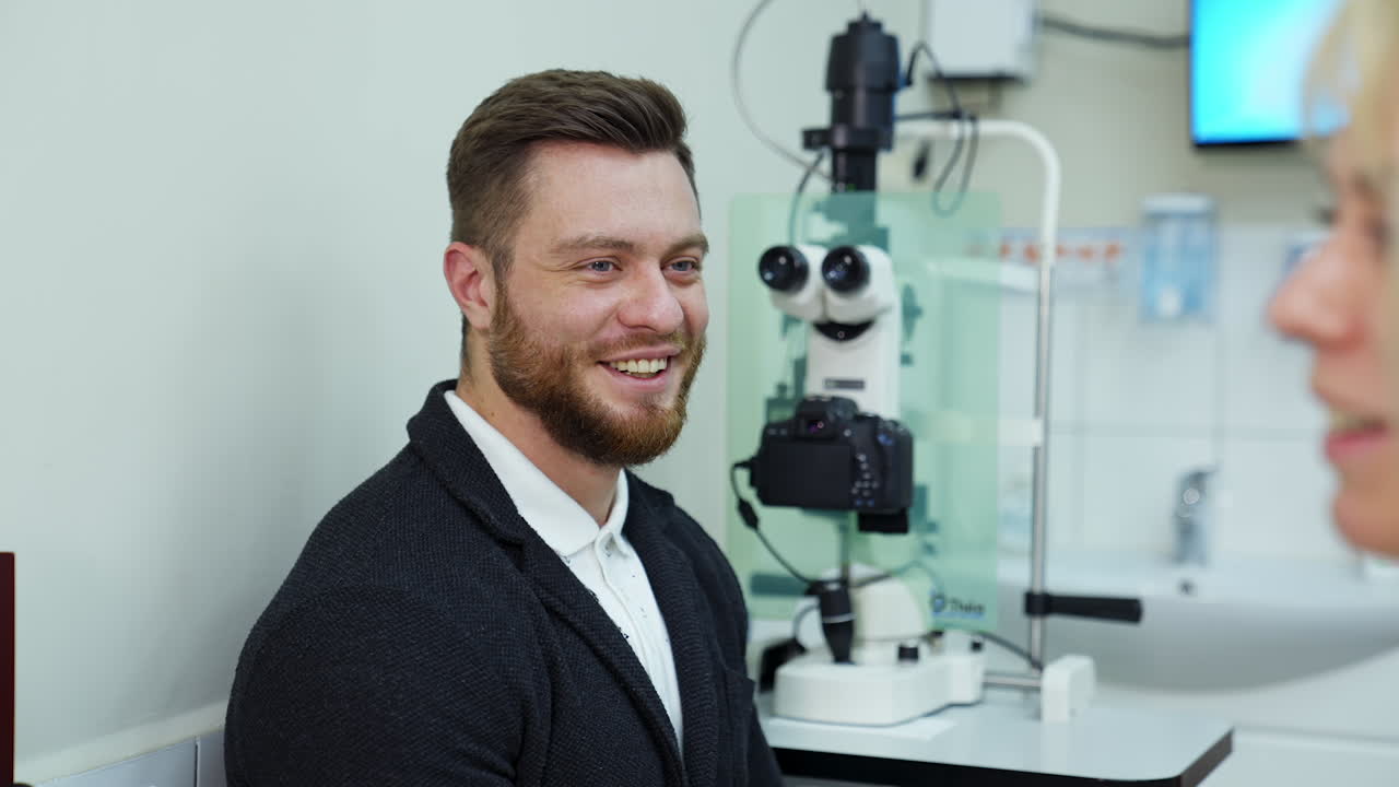 Cheerful young man came to consultation in ophthalmology clinic. Happy man gets happy news about health. Planned visit to clinic.