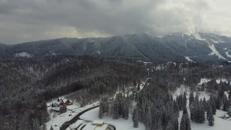 a picturesque mountain resort surrounded by a thick white blanket of snow with fir trees and thick clouds in the background, located in the beautiful poiana brasov, romania