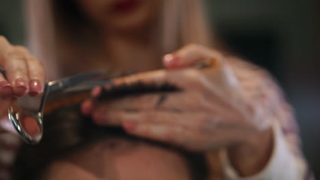 Close-up-hairdresser-with-scissors-and-comb.-Blurred-background.