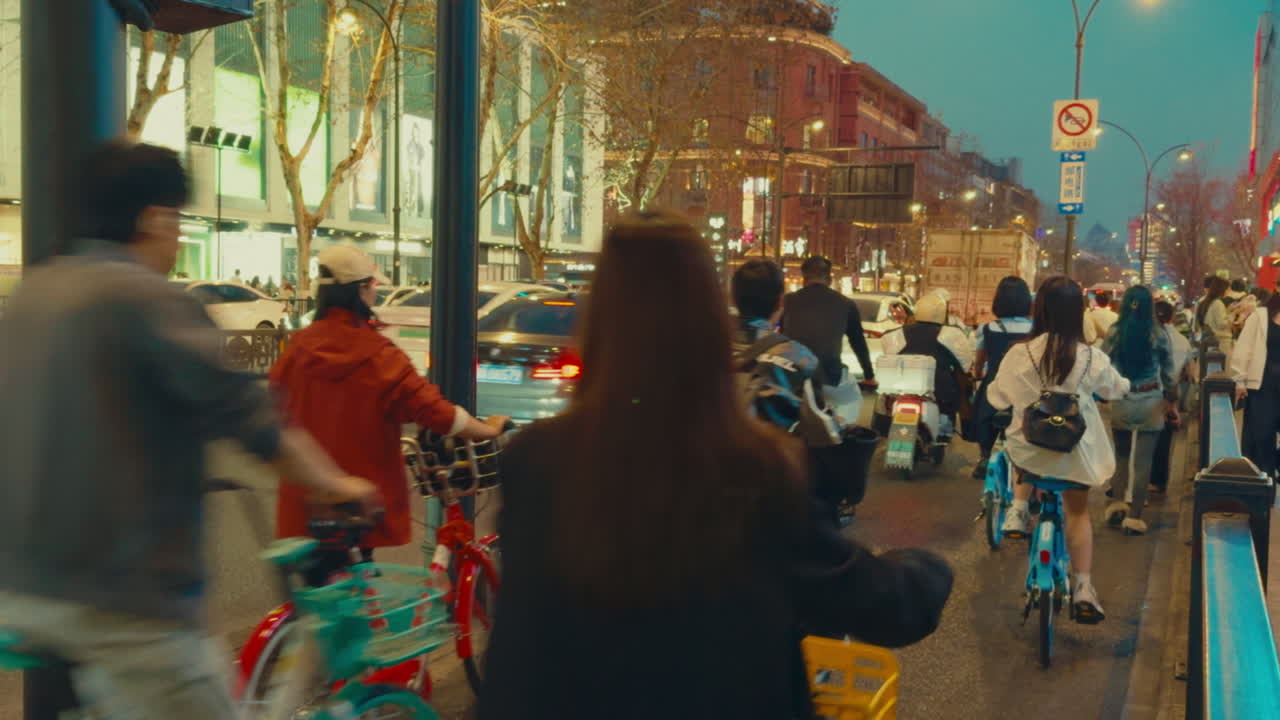 Night Scene of a Busy City Street with Cyclists and Pedestrians