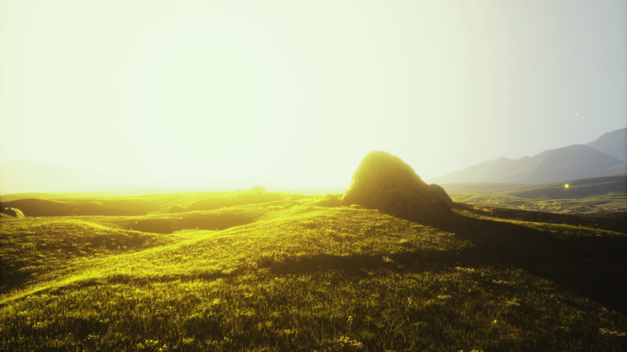 Golden sunrise illuminates rolling hills with tranquil landscape