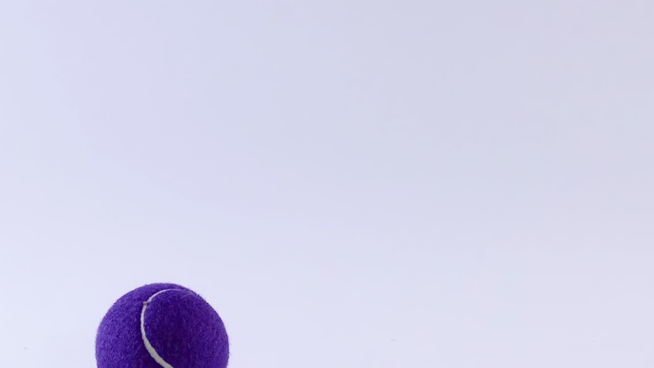 A purple tennis ball captured in various mid-air positions against a plain background.