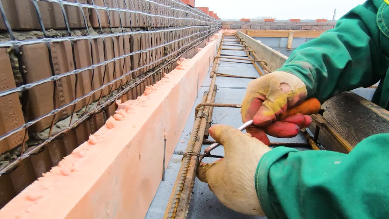 Construction Worker Installing Rebar and Insulation