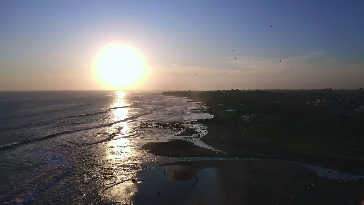 바다의 파도에 여있는 칸구 해변에서 해가 지고, 공중에서 kite, 발리