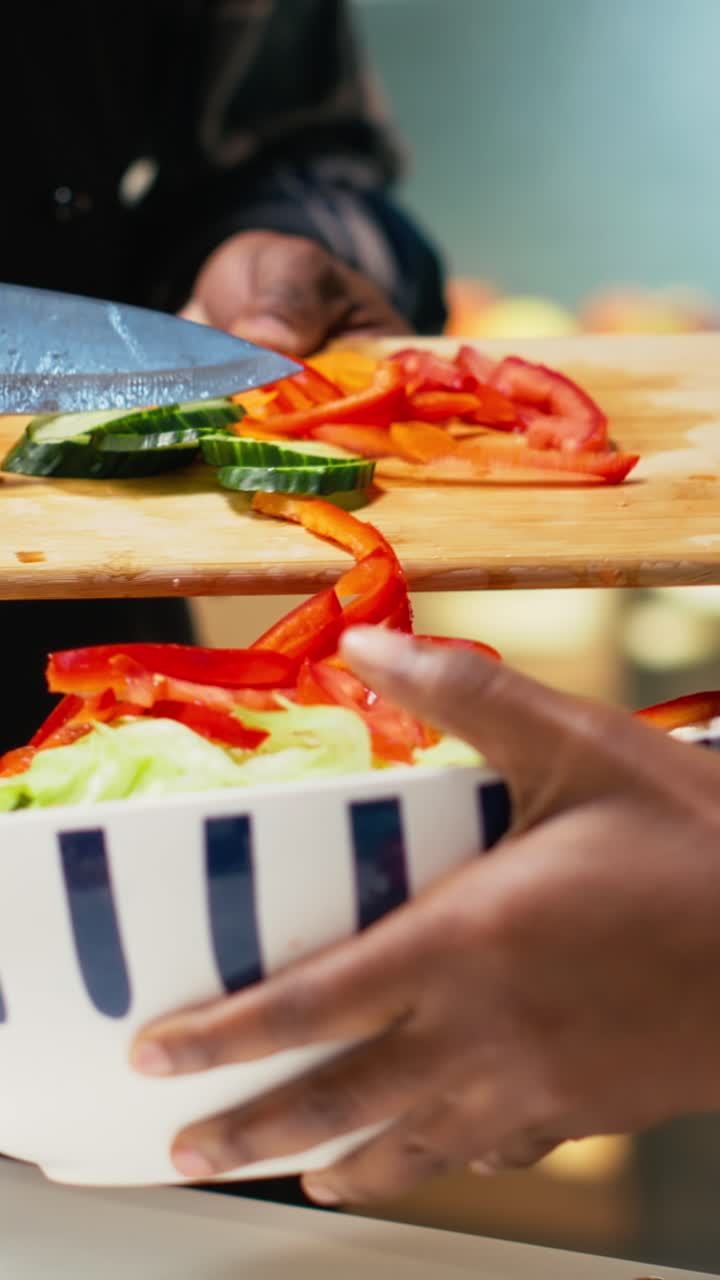 Vertical Video Black young people cutting fresh vegetables and adding in a bowl