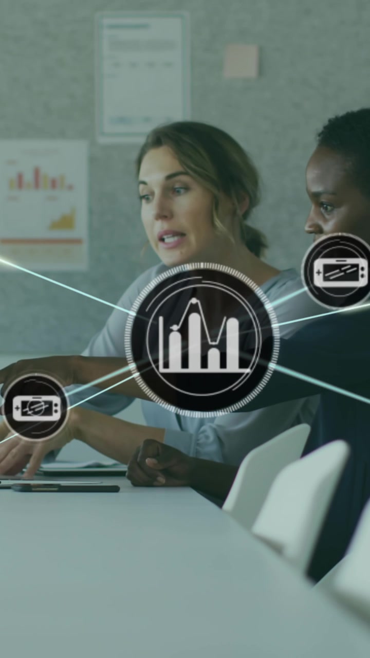 Animation of connected icons over diverse female coworkers discussing report on laptop at office